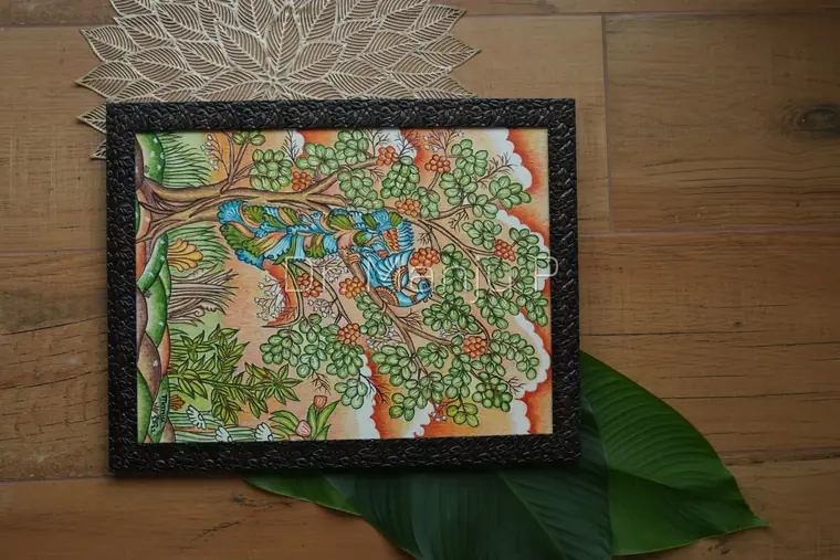 Peacock On the Flowering Tree — Kerala mural detail: Seen at a slight angle on the wooden table — the raised beading of the frame catching light