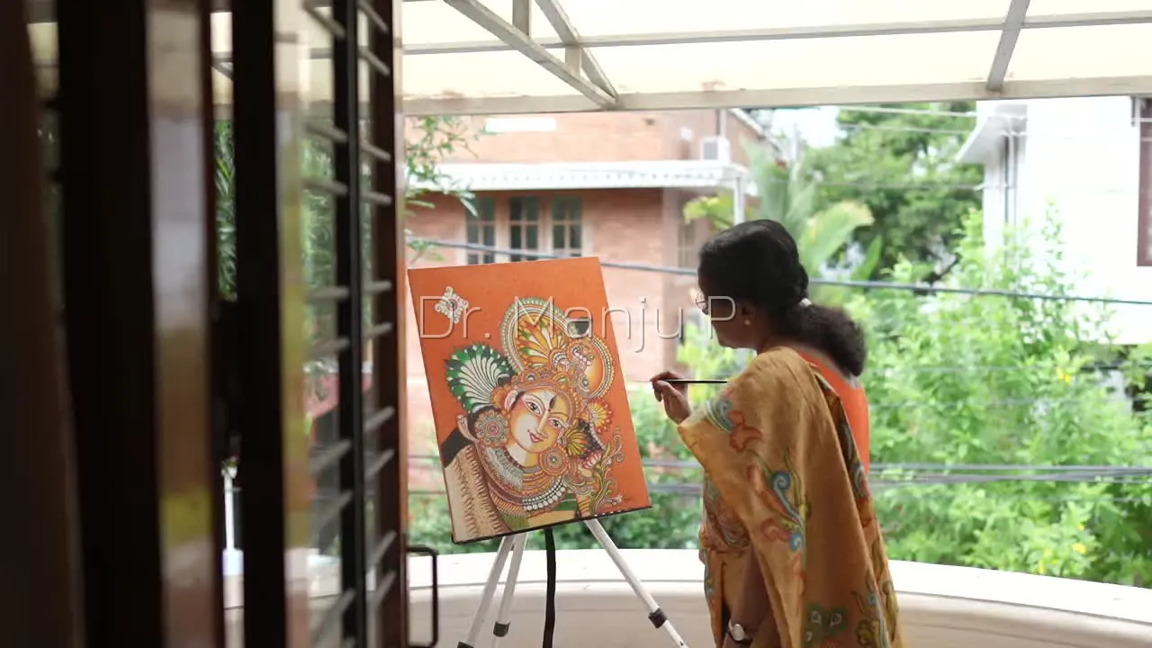 Dr. Manju P at work on a Kerala mural painting in her Kerala studio